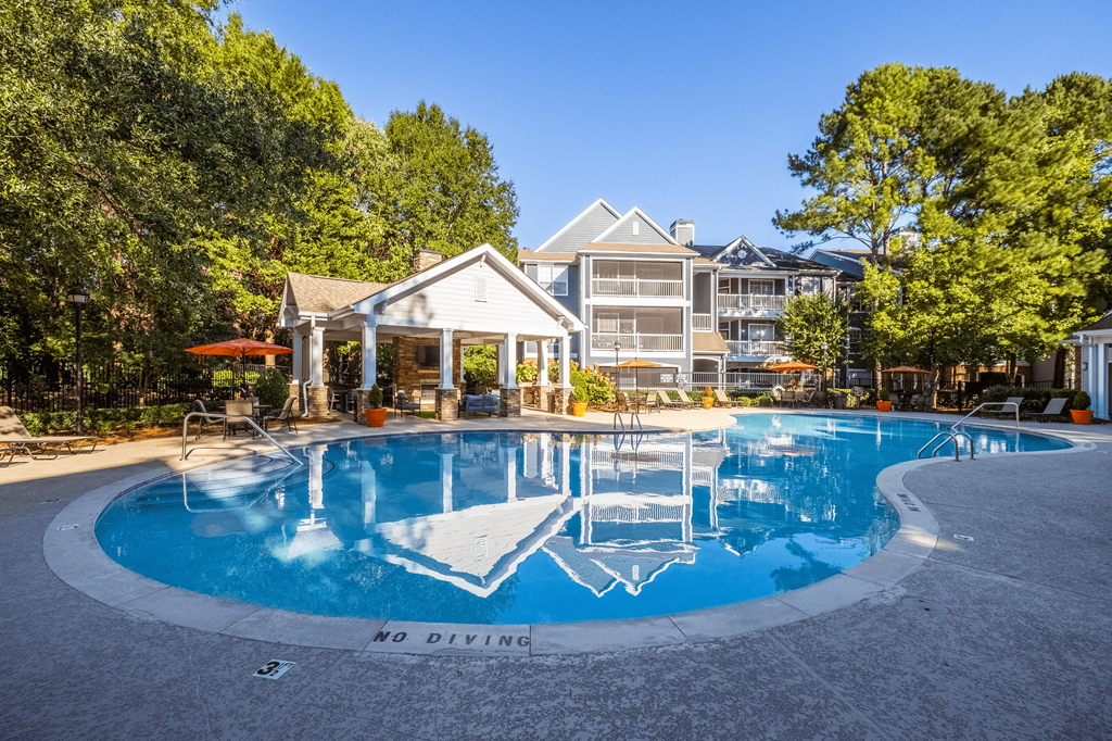 a large pool with a house in the background