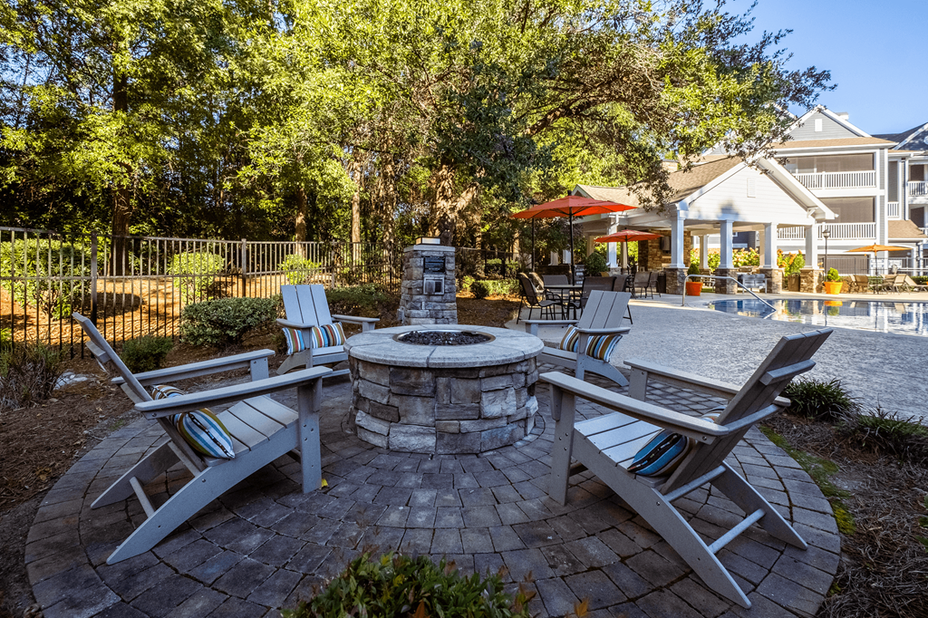 a patio with chairs and a fire pit and a pool