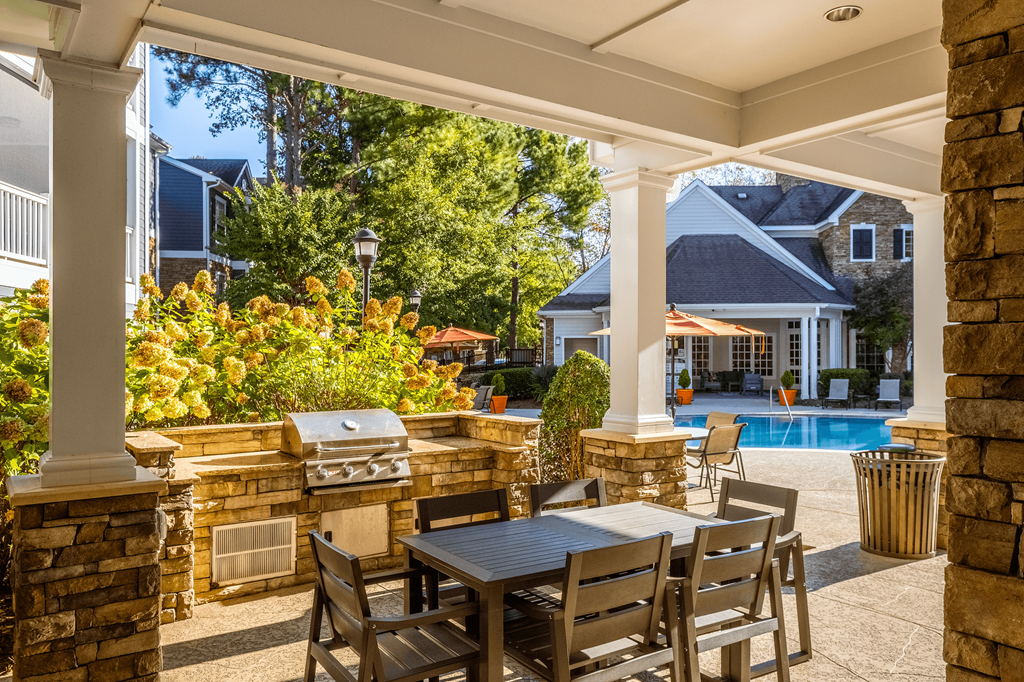 a patio with a table and chairs and a swimming pool