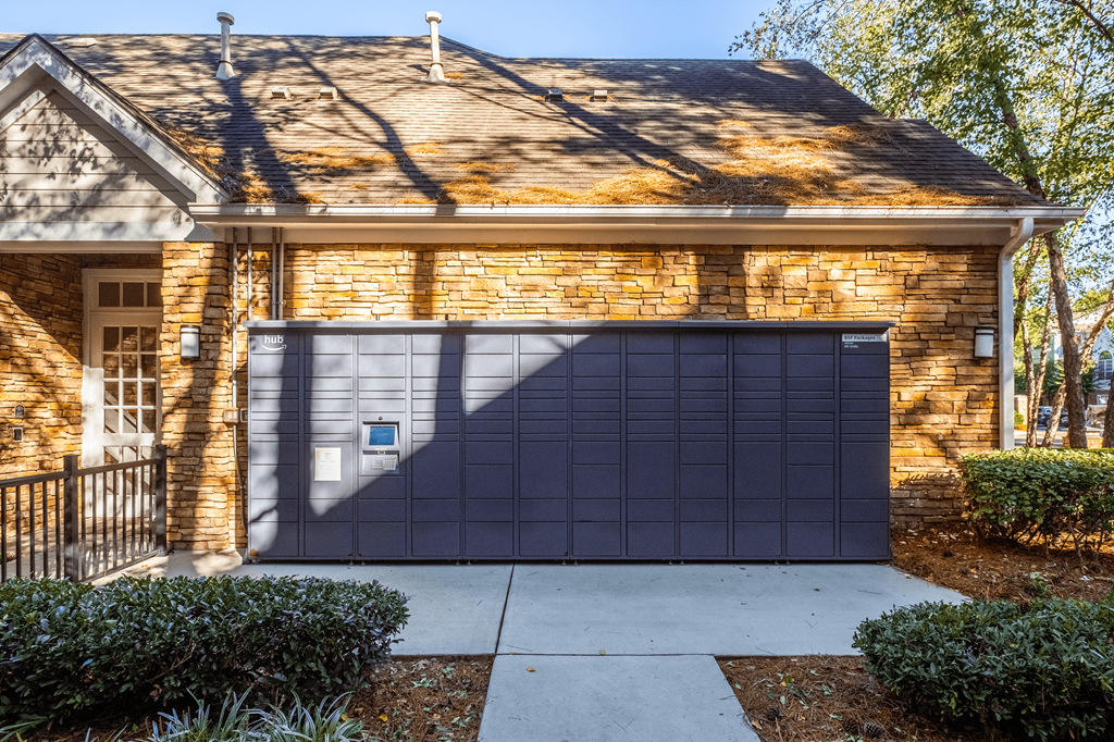 A house with a grey garage door and a brick wall.