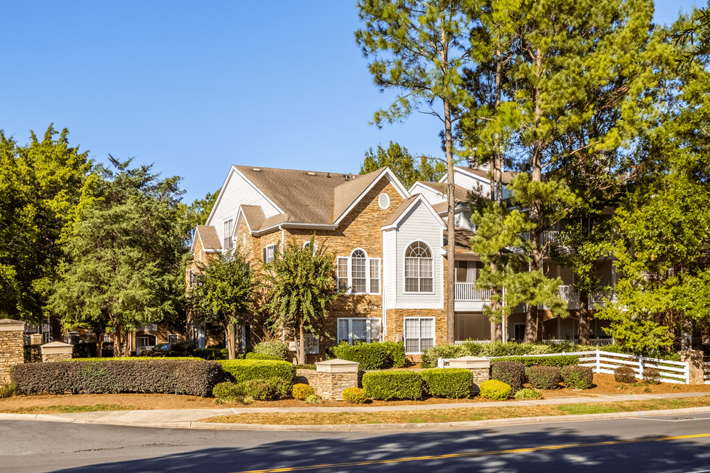 a house on the corner of a street with trees