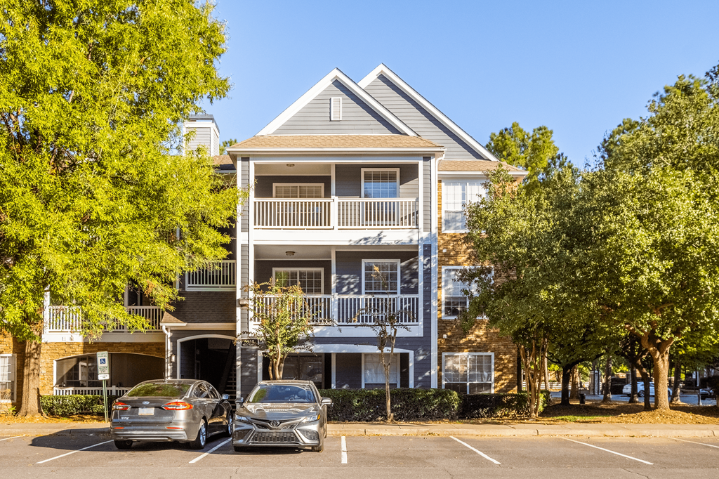 an apartment building with two cars parked in front of it
