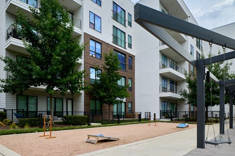 A playground area in front of a modern apartment building.