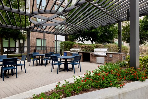 A patio with tables and chairs under a metal roof.