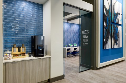 A room with a blue wall and a black fridge.