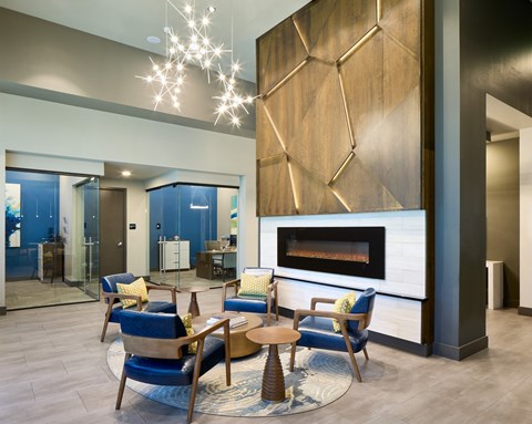 A modern living room with a fireplace and blue chairs.