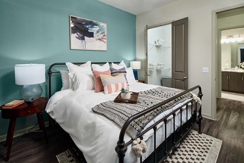 A bedroom with a large bed and a painting on the wall.