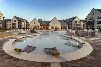 a large swimming pool with chairs in an apartment complex
