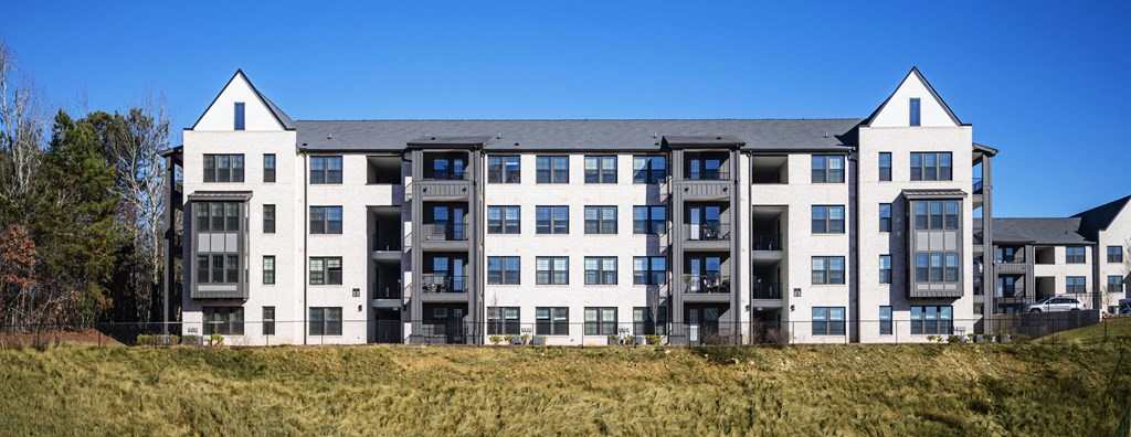 a large apartment building with two towers on top of a hill