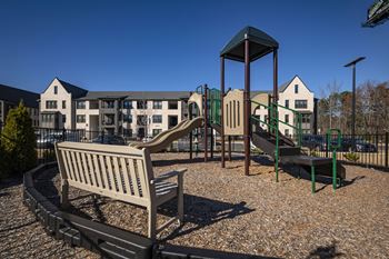 a playground with a slide and a bench in a park