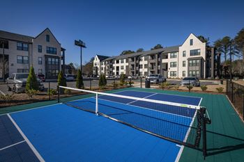 two tennis courts with apartments in the background