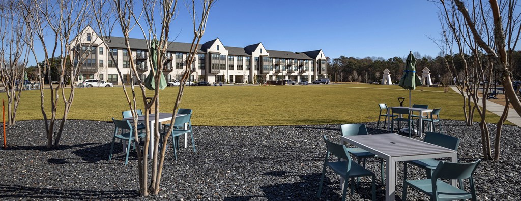 a park with tables and chairs in front of a building
