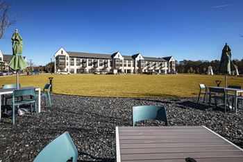a view of a building from a patio with tables and chairs