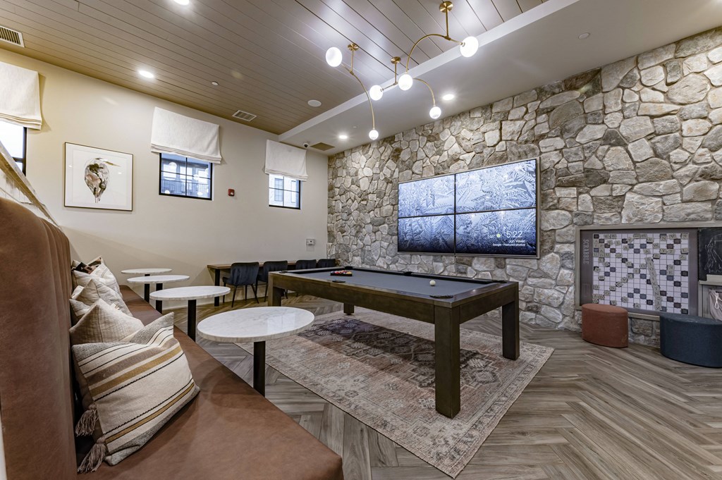 a billiards table in a clubhouse with a stone wall