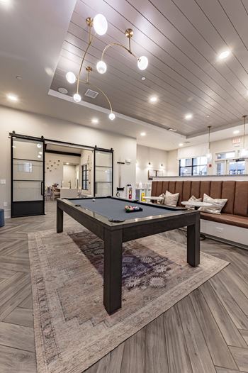 a billiards table in a clubhouse with couches