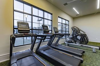 gym with cardio equipment and windows at the district flats apartments in lenexa