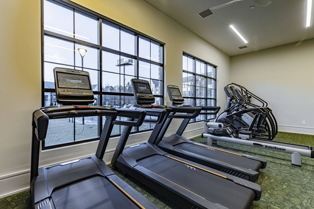 gym with cardio equipment and windows at the district flats apartments in lenexa