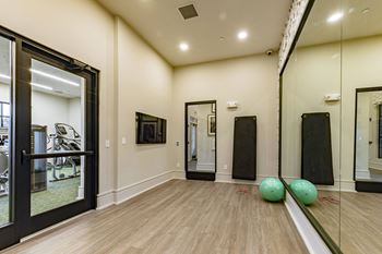 a fitness room with mirrors and balls on the floor