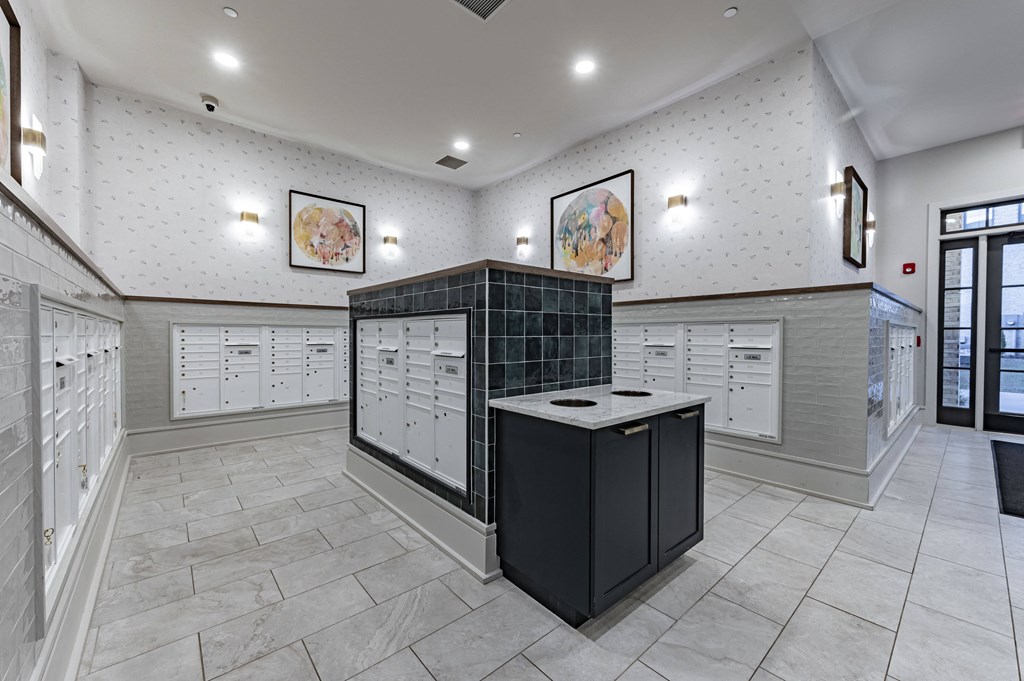 a locker room with white cabinets and counters and a black counter top in the center
