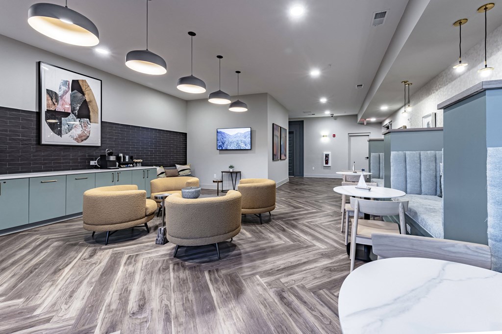 a lounge area with chairs and tables and a television