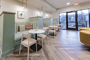 a seating area with tables and chairs and a balcony