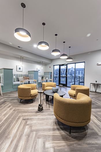 a lounge area with chairs and tables in the lobby of a building