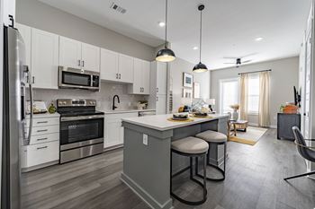 an open kitchen with a large island with two stools