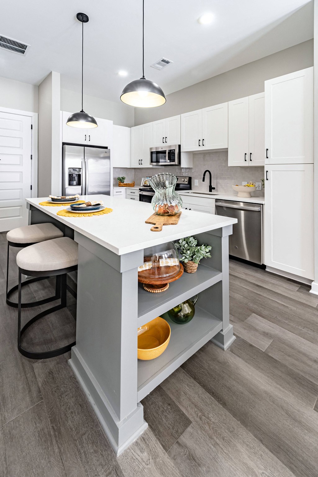 an open kitchen with a large island with two stools