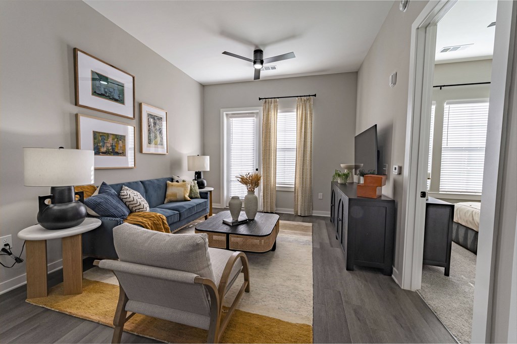 our apartments offer a spacious living room with a couch and a tv