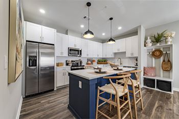kitchen with island with stools and a stainless steel refrigerator