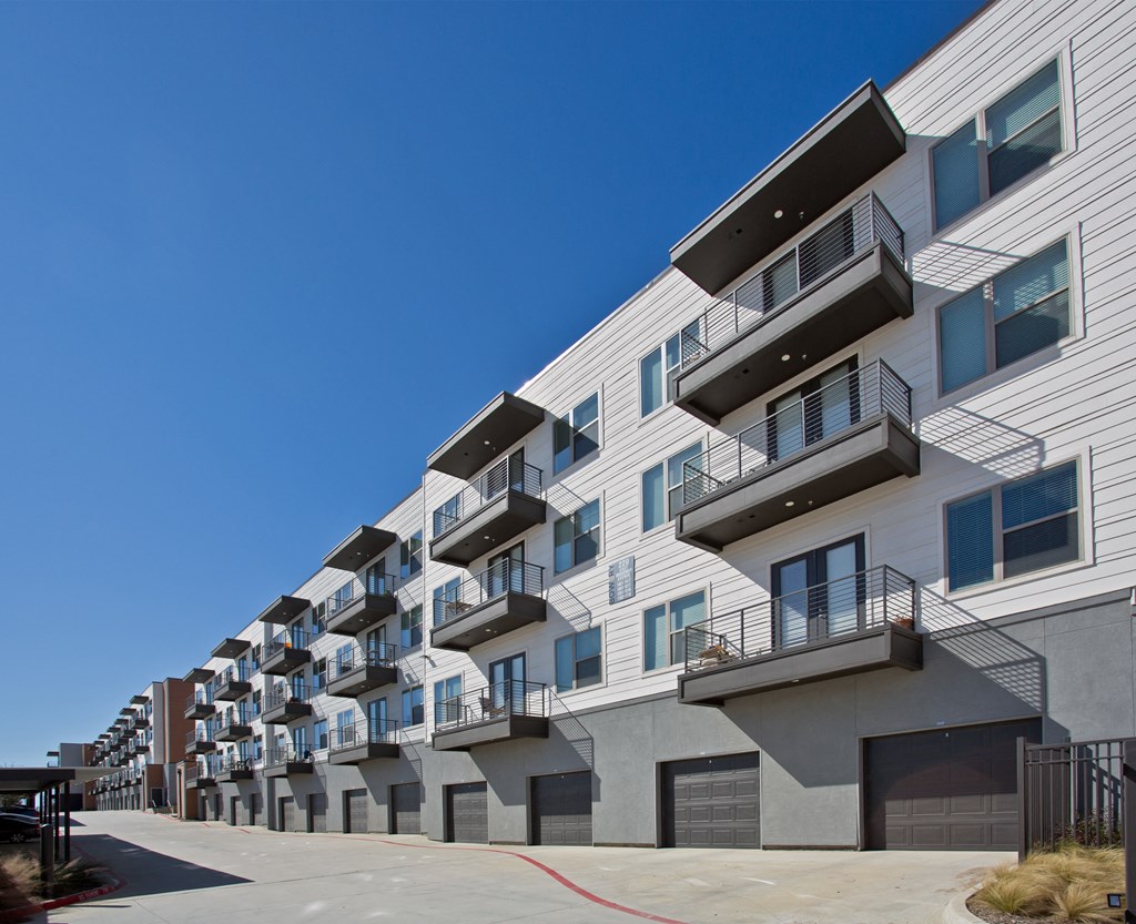 a row of apartment buildings with balconies and a blue sky