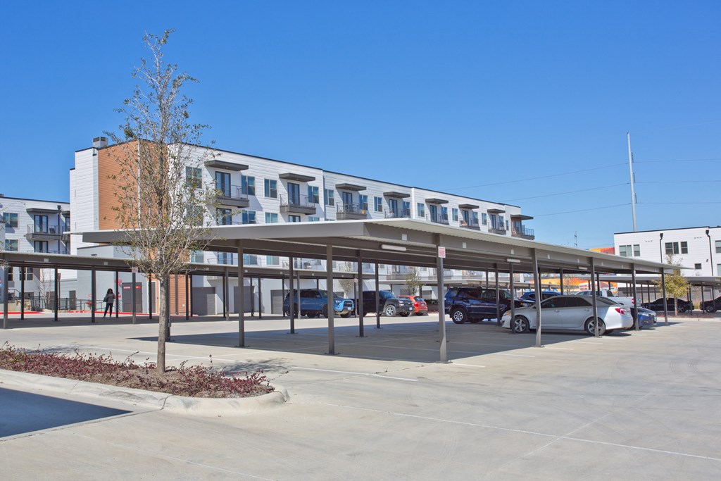 a large building with a parking lot with cars in front of it