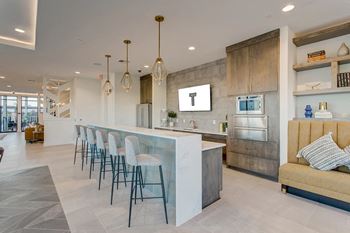 the kitchen and bar area of a modern restaurant with bar stools