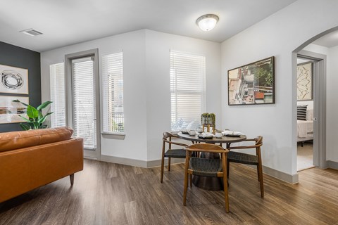 a dining area with a wooden table and chairs and a leather couch