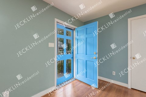 A blue door is open to a hallway.