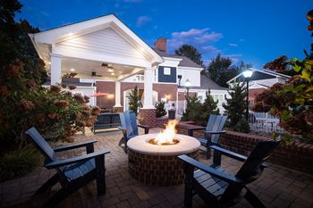 a backyard patio with a fire pit and chairs