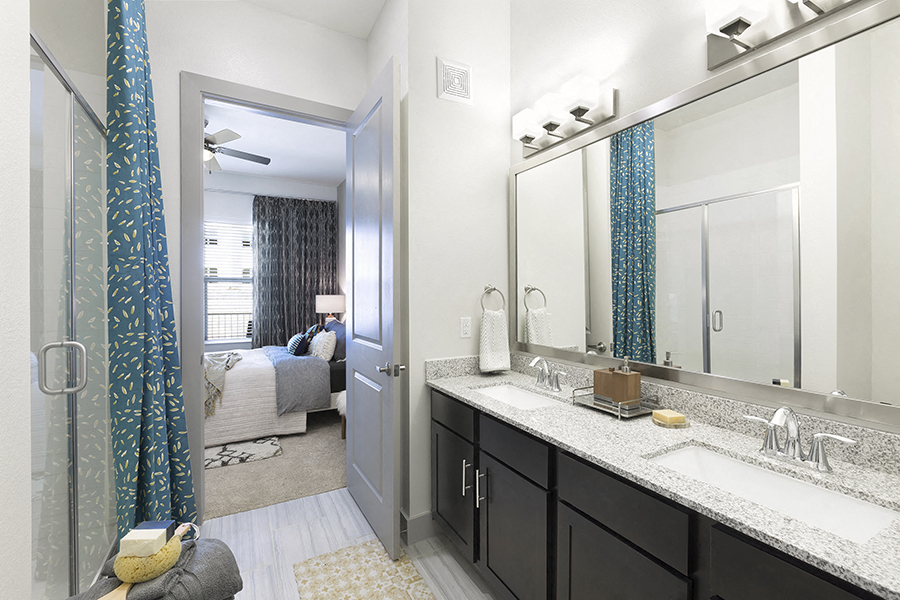 a bathroom with dual sinks and a large mirror