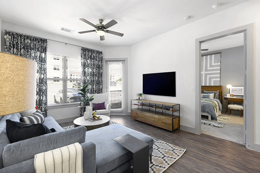 a living room with a ceiling fan and a tv