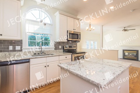 a kitchen with granite counter tops and white cabinets
