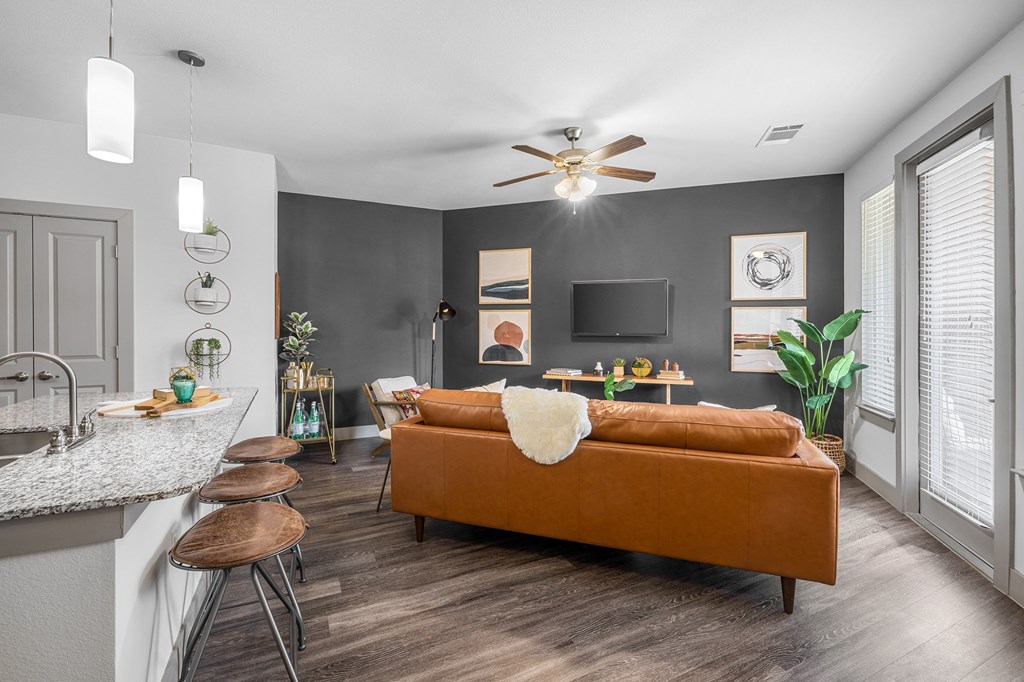 breakfast bar area overlooking living area with sofa, tv and art on the walls