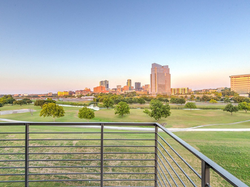 a view of the city skyline from a balcony overlooking a park