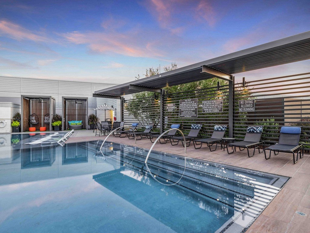 a swimming pool with lounge chairs and a roofed pool