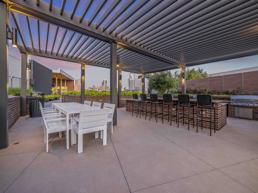 a patio with tables and chairs under awning