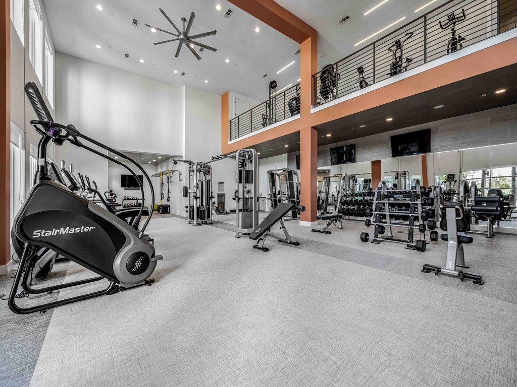 a gym with weights and cardio equipment in the lobby of a building