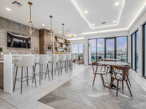 A modern kitchen with a bar area and a dining table.