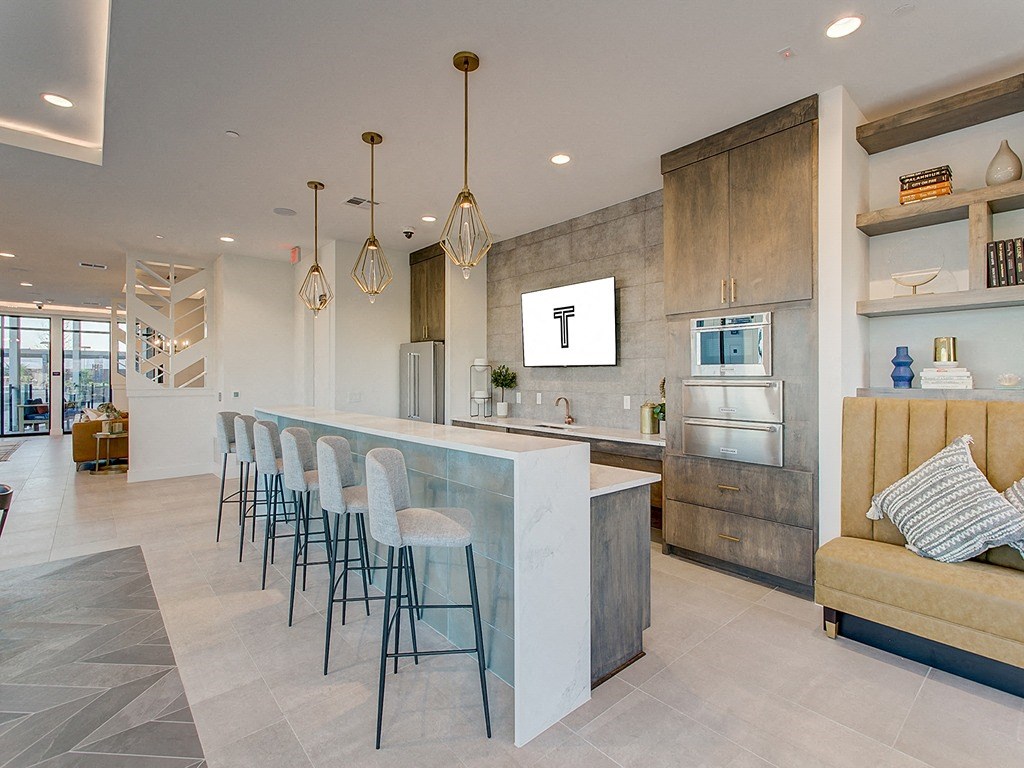 a large kitchen with a bar and chairs in front of it