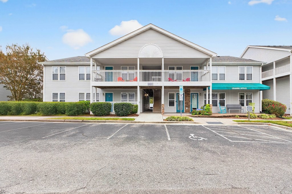 A large building with a parking lot in front.at Lofts of Wilmington, North Carolina
