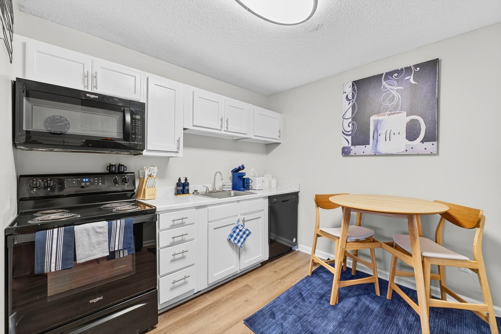 A kitchen with a black stove and white cabinets.at Lofts of Wilmington, Wilmington, NC