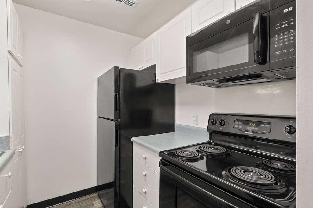 Kitchen with white cabinetry and black appliances at Creve Coeur, Creve Coeur, MO