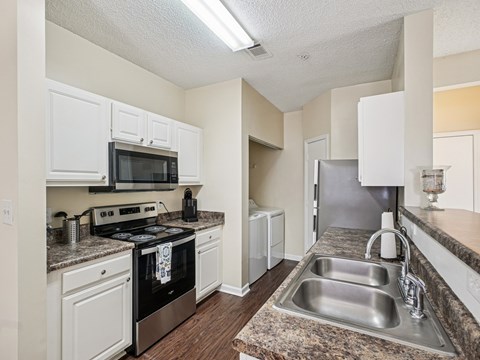 A kitchen with a black oven and white cabinets.